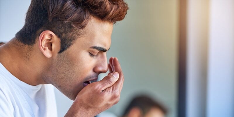 man checking for bad breath in bathroom, morning routine for halitosis problem