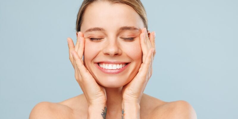 closeup of a woman smiling against a light blue back ground