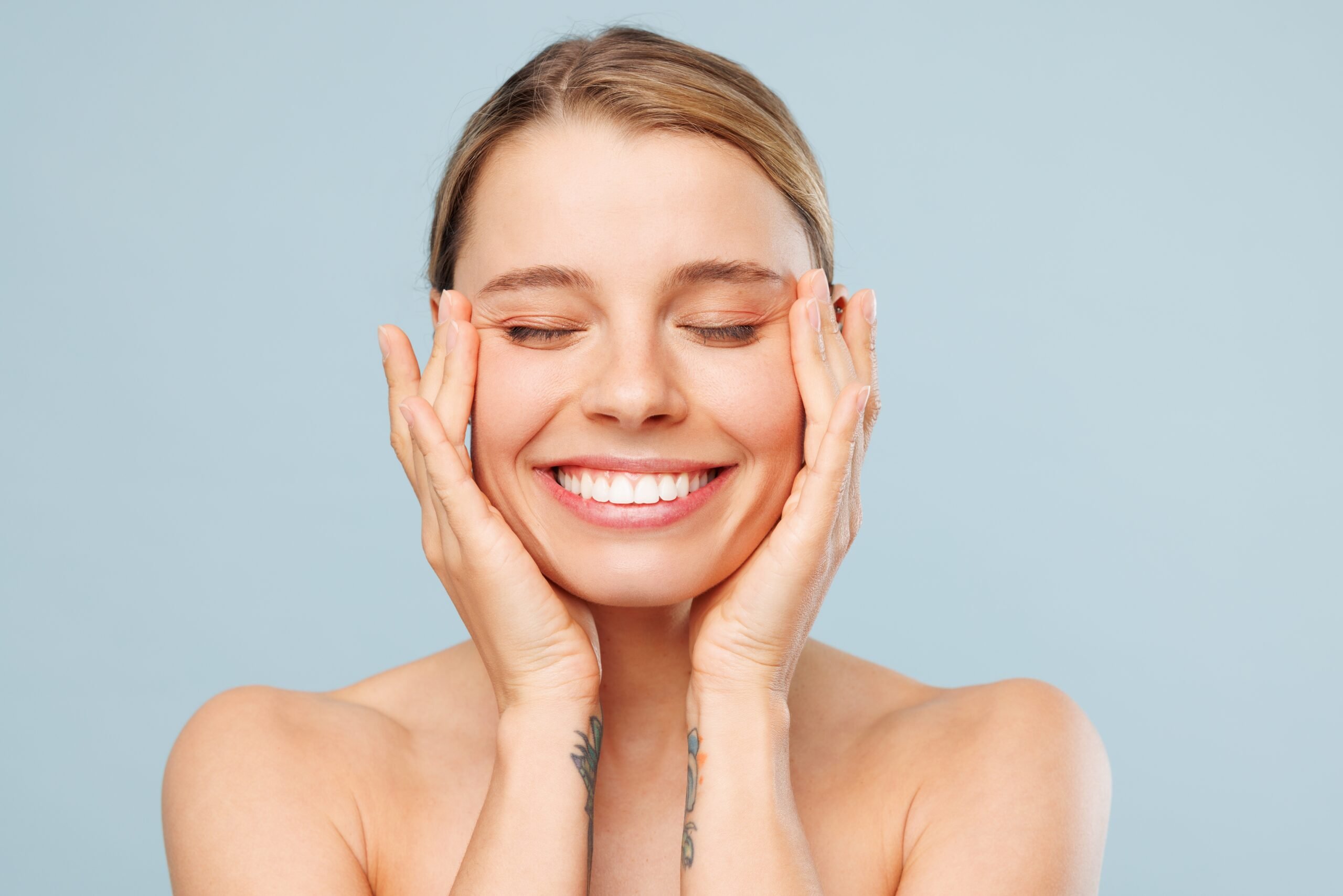 closeup of a woman smiling against a light blue back ground