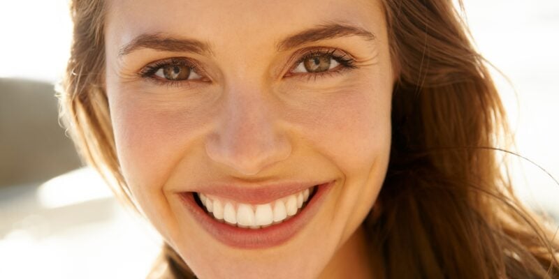 Portrait, smile and woman on beach with perfect teeth
