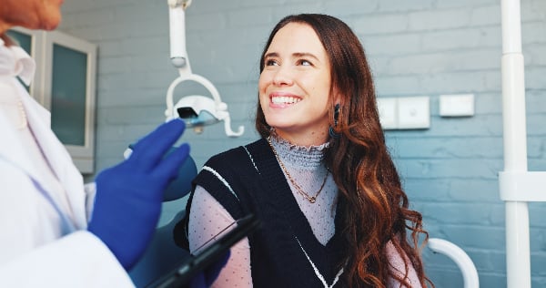 young woman smiling in a dental office, routine cleaning