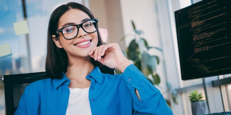 young woman smiling confidently in an office, perfect white teeth