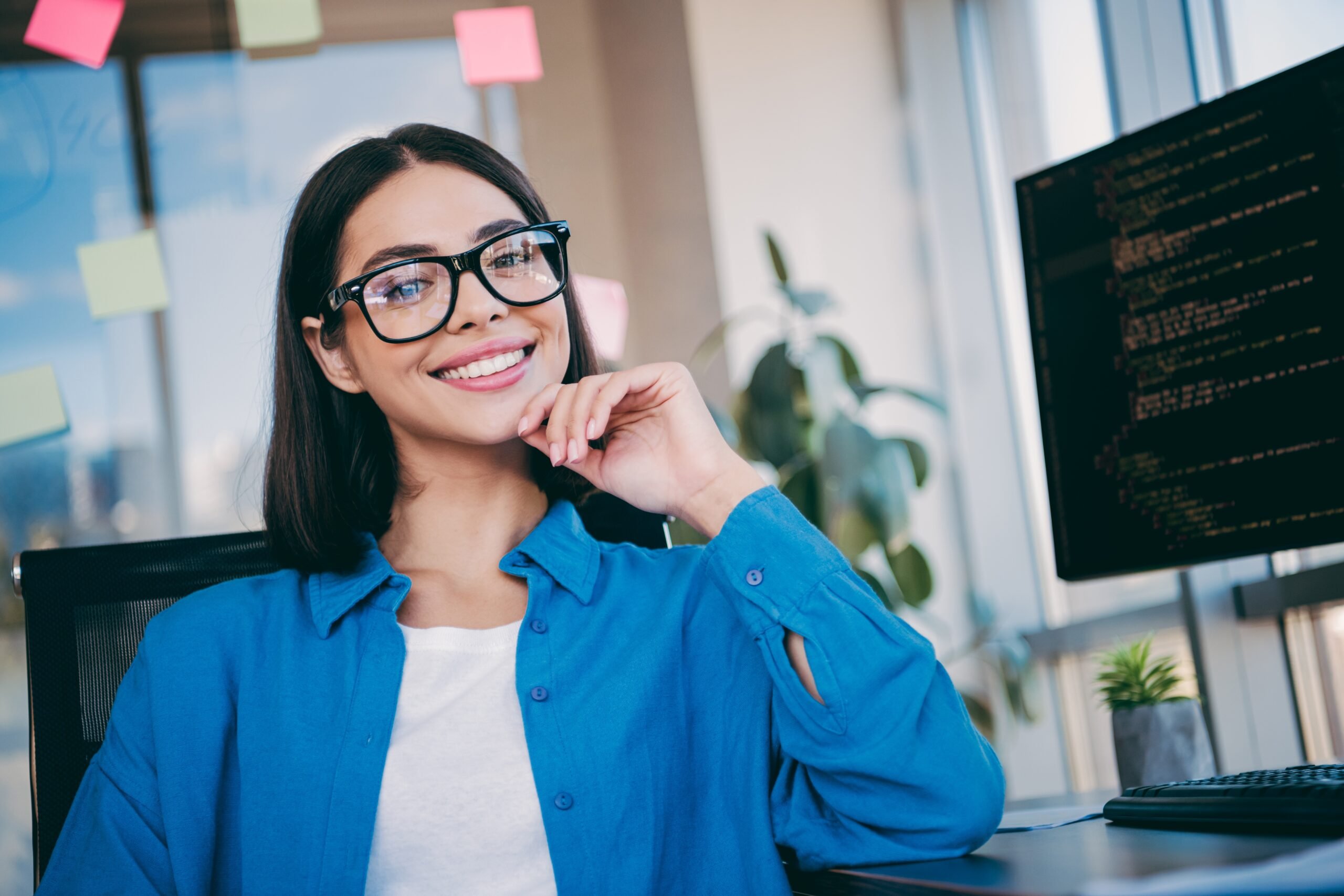 young woman smiling confidently in an office, perfect white teeth