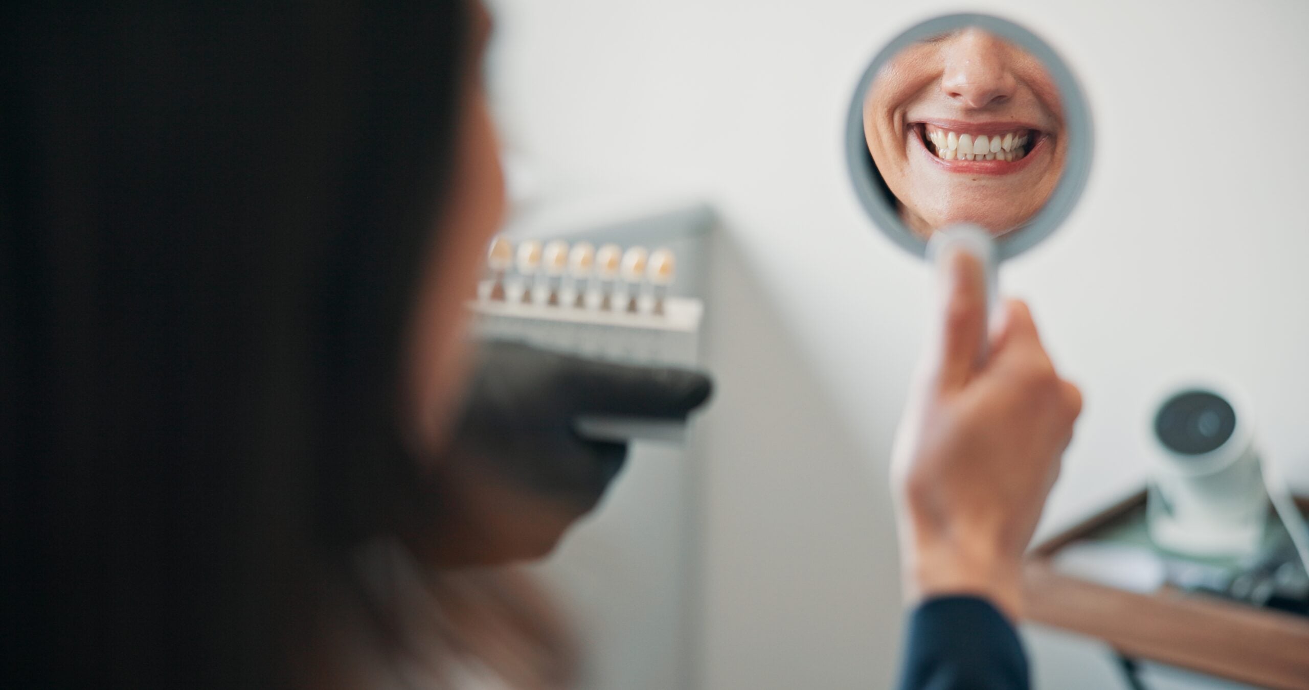 Happy woman, mirror in hand looking at new crown