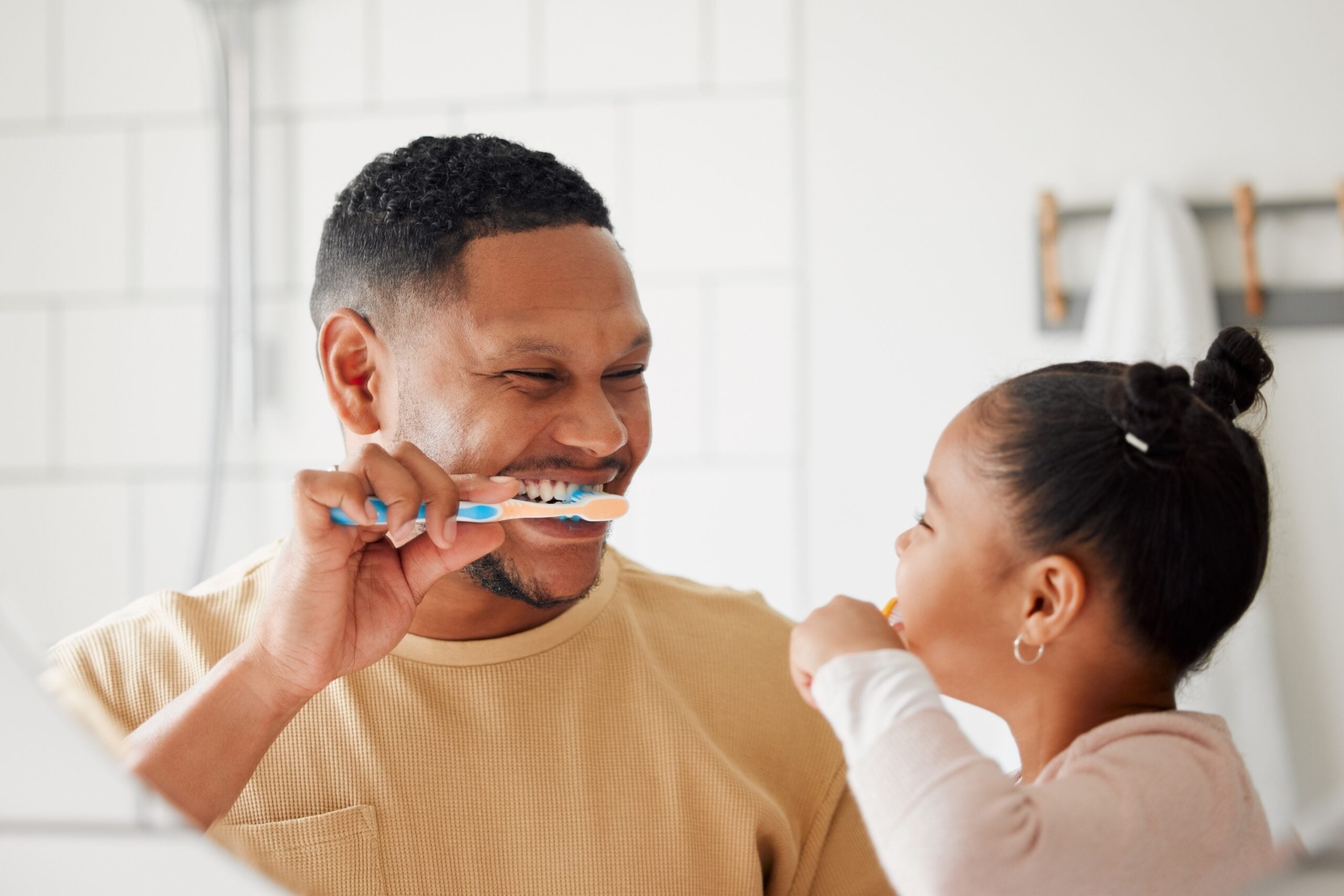 Father, child, and brushing teeth in a bathroom
