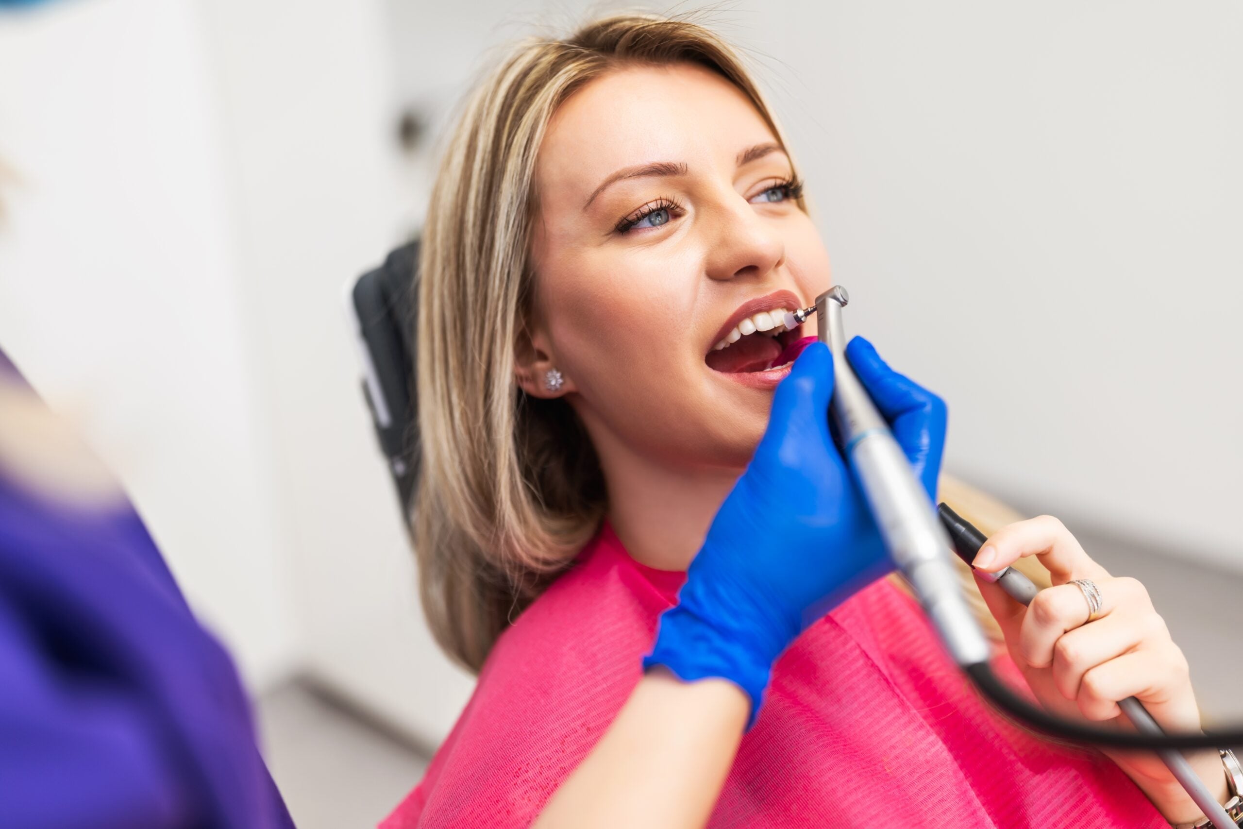 dentist using dental bonding to repair a female patients front tooth