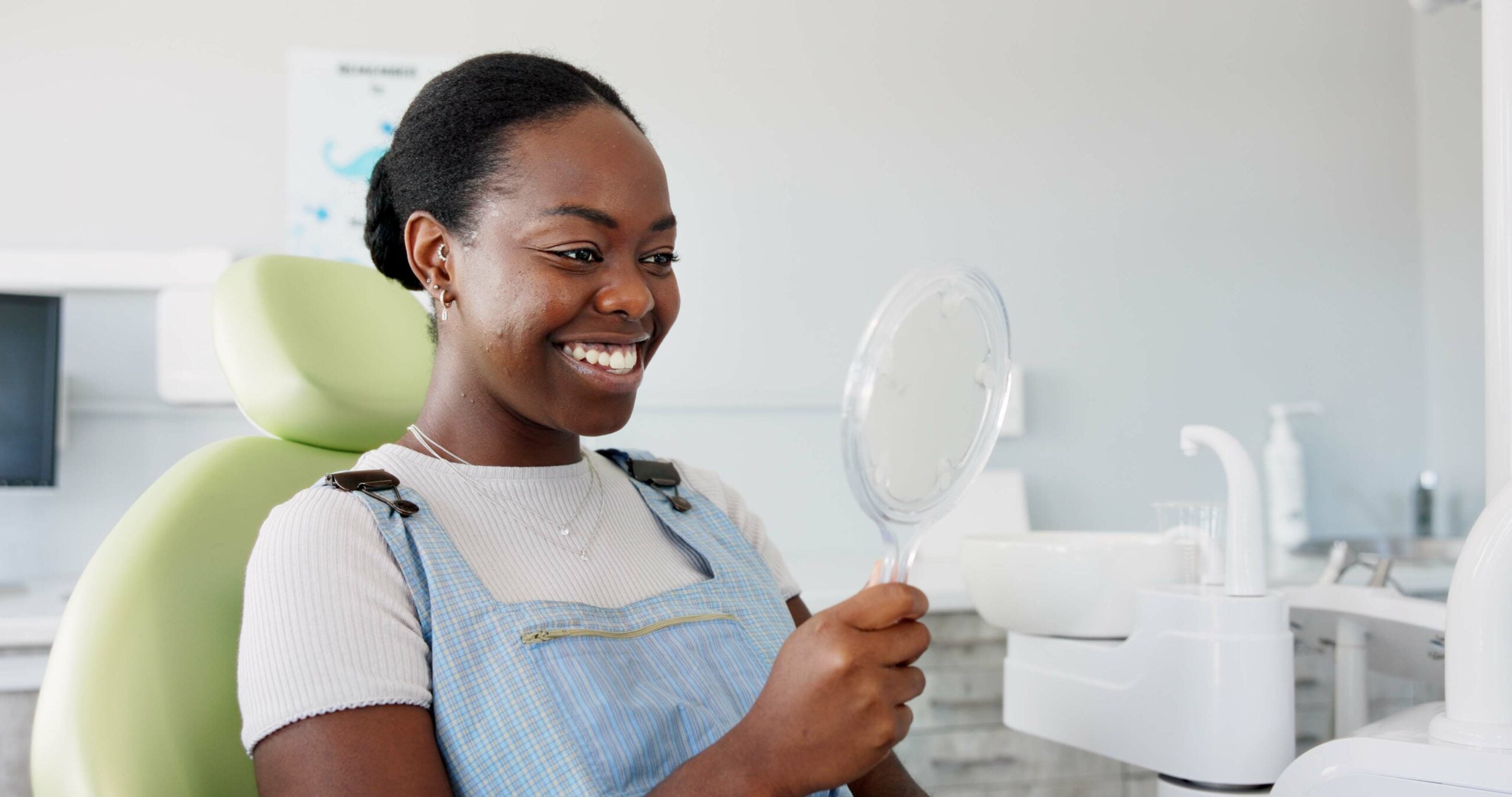 happy woman in a dental chair, newly bonded teeth
